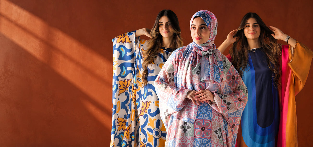 Three Tallah Malhafa looks in pink patchwork, blue-and-yellow print and rainbow satin against a terracotta backdrop.