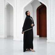 Model wearing Tallah's black CY Isdal with diagonal gold trim, gallery photo 1