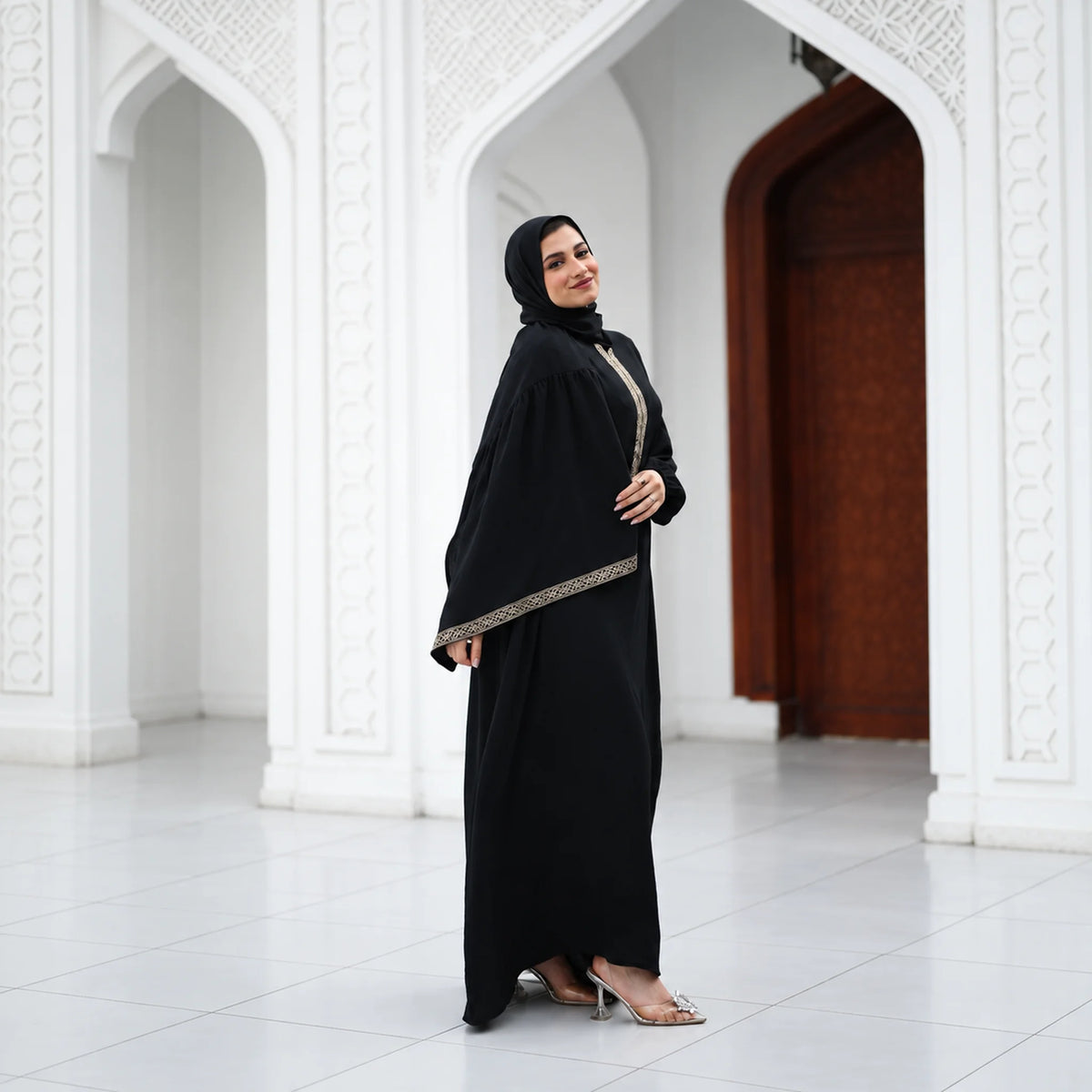 Model wearing Tallah's black CY Isdal with diagonal gold trim, gallery photo 1