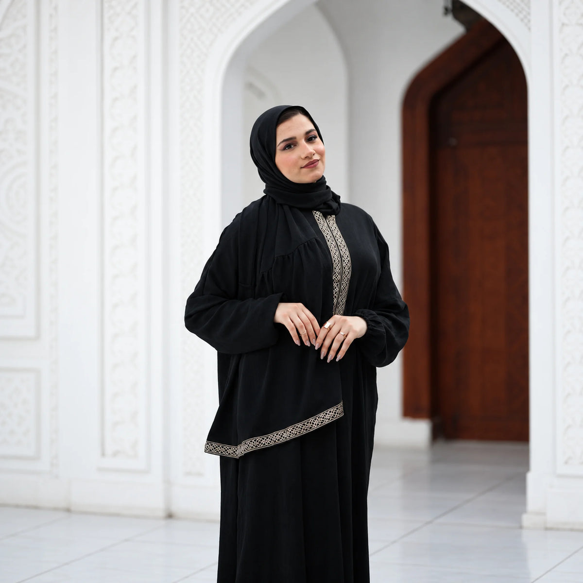 Model wearing Tallah's black CY Isdal with diagonal gold trim, gallery photo 2