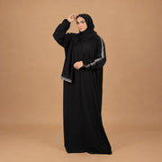 Model wearing Tallah's black CY Isdal with silver trim on sleeves and hem, gallery photo 1