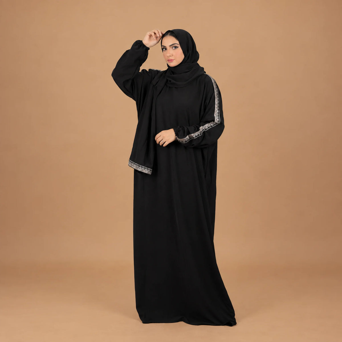 Model wearing Tallah's black CY Isdal with silver trim on sleeves and hem, gallery photo 1