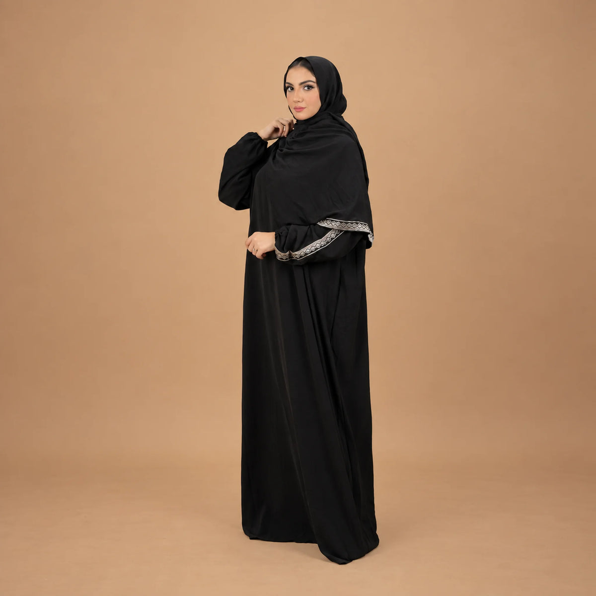Model wearing Tallah's black CY Isdal with silver trim on sleeves and hem, gallery photo 2