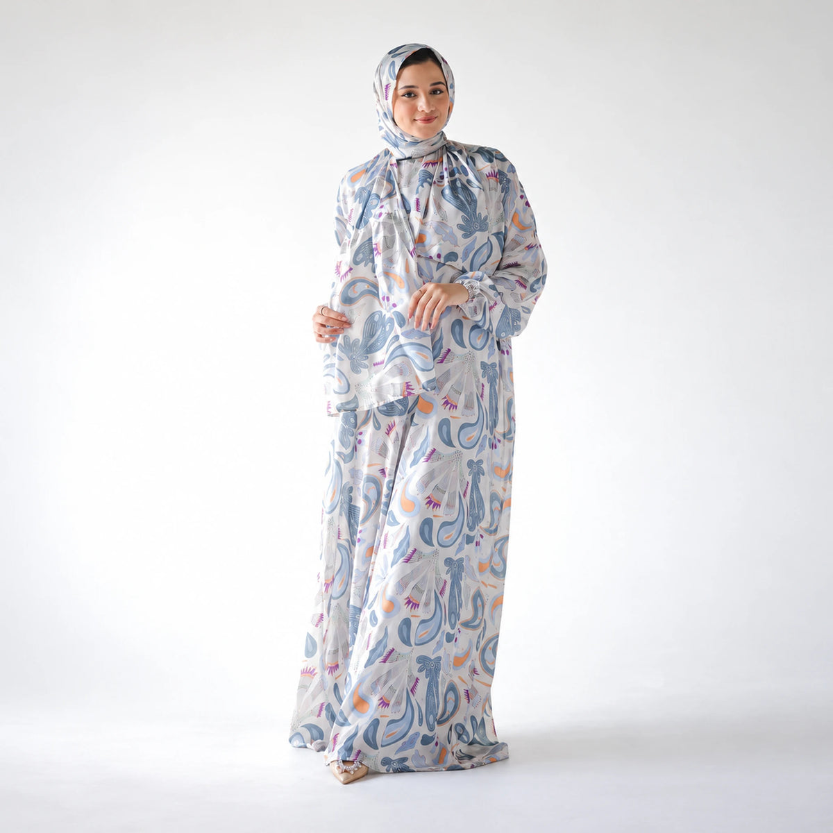 Alternate front view of a blue and white abstract-print CY Isdal with a matching head covering.