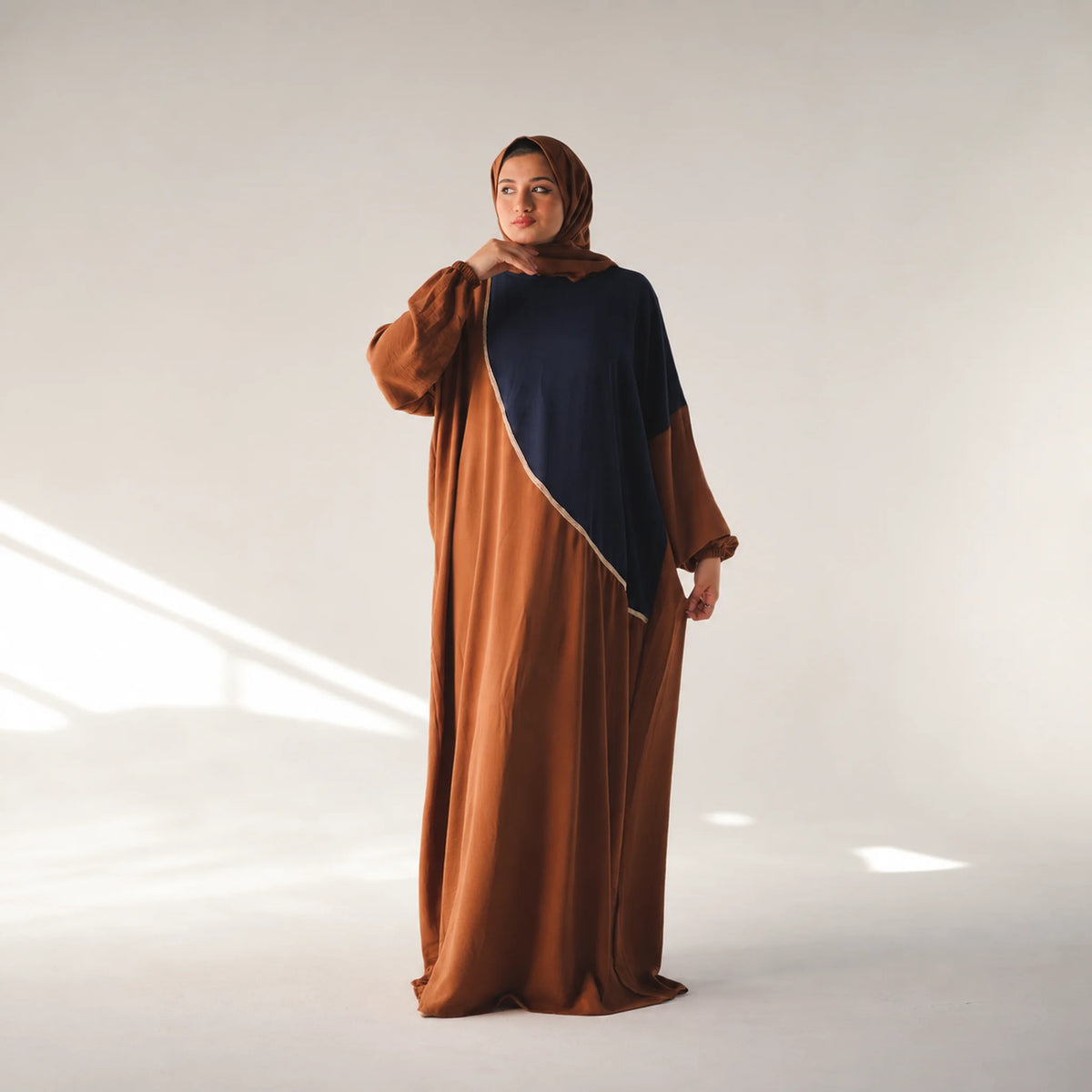 Model wearing Tallah's brown CY Isdal with navy colour-block panel, gallery photo 1