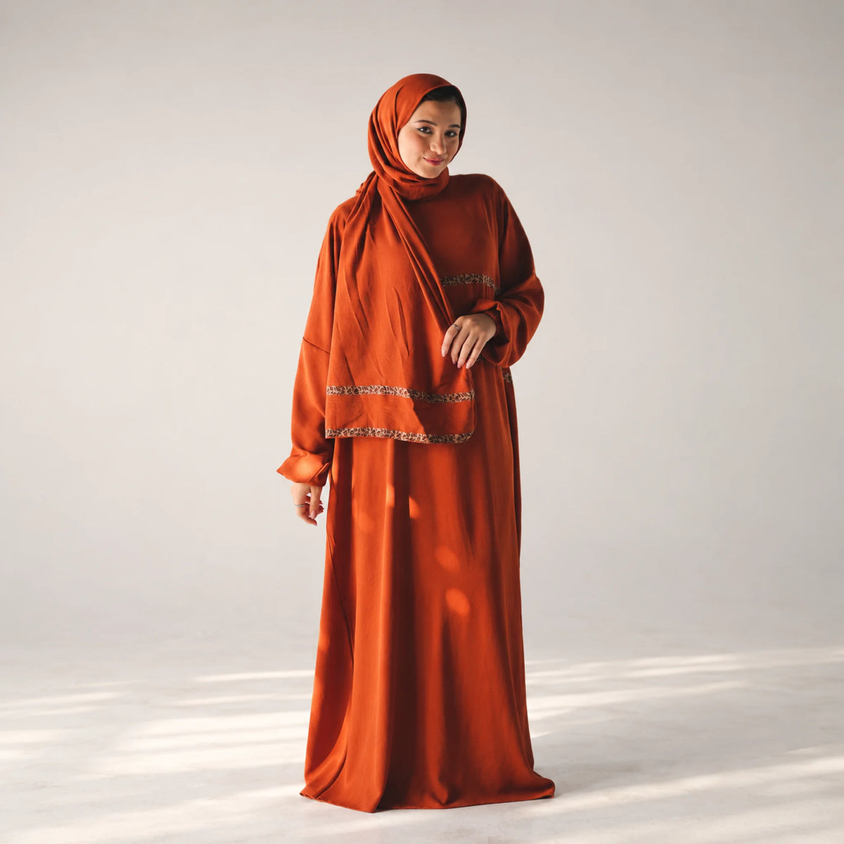 Model wearing Tallah's burnt-orange CY Isdal with leopard trim, gallery photo 1