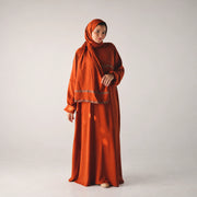 Model wearing Tallah's burnt-orange CY Isdal with metallic trim, gallery photo 1