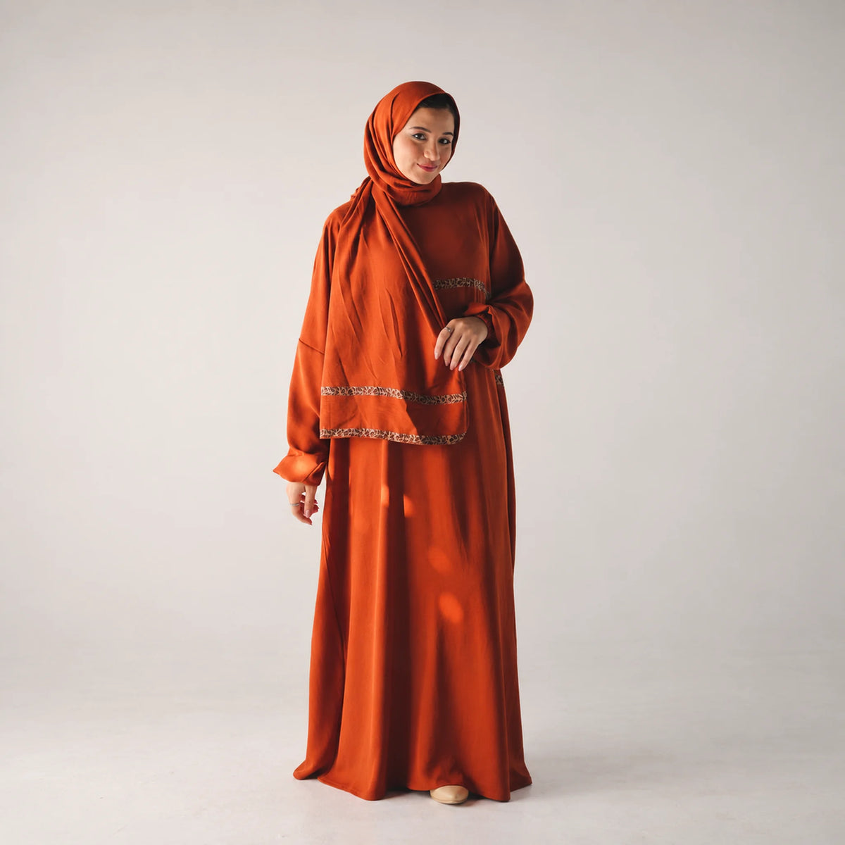 Model wearing Tallah's burnt-orange CY Isdal with metallic trim, gallery photo 1