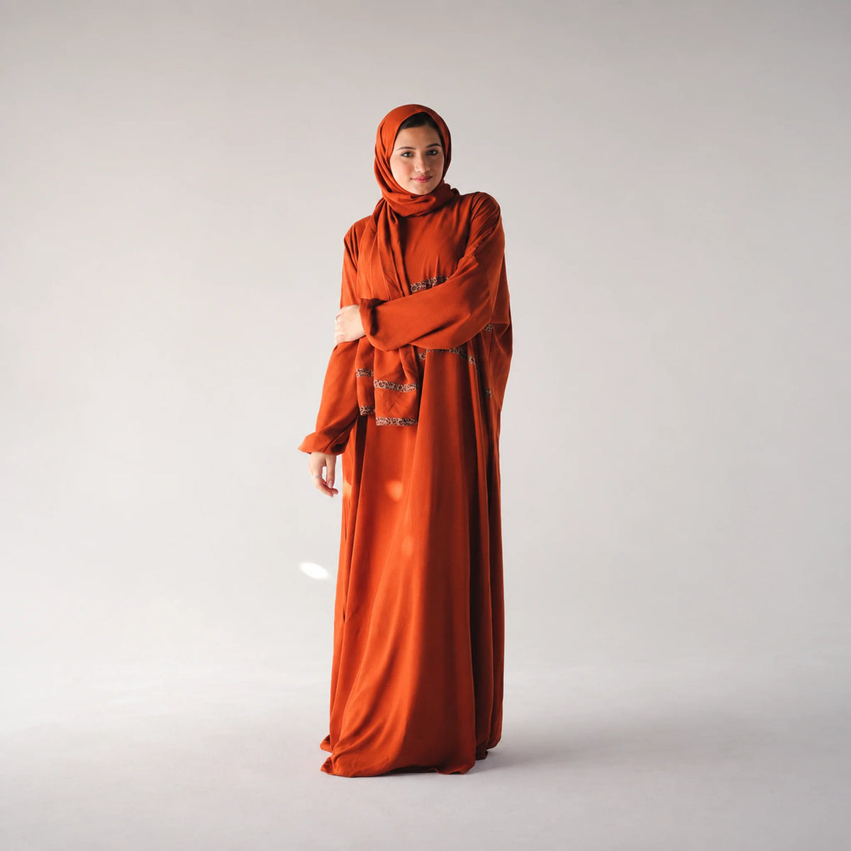 Model wearing Tallah's burnt-orange CY Isdal with metallic trim, gallery photo 2