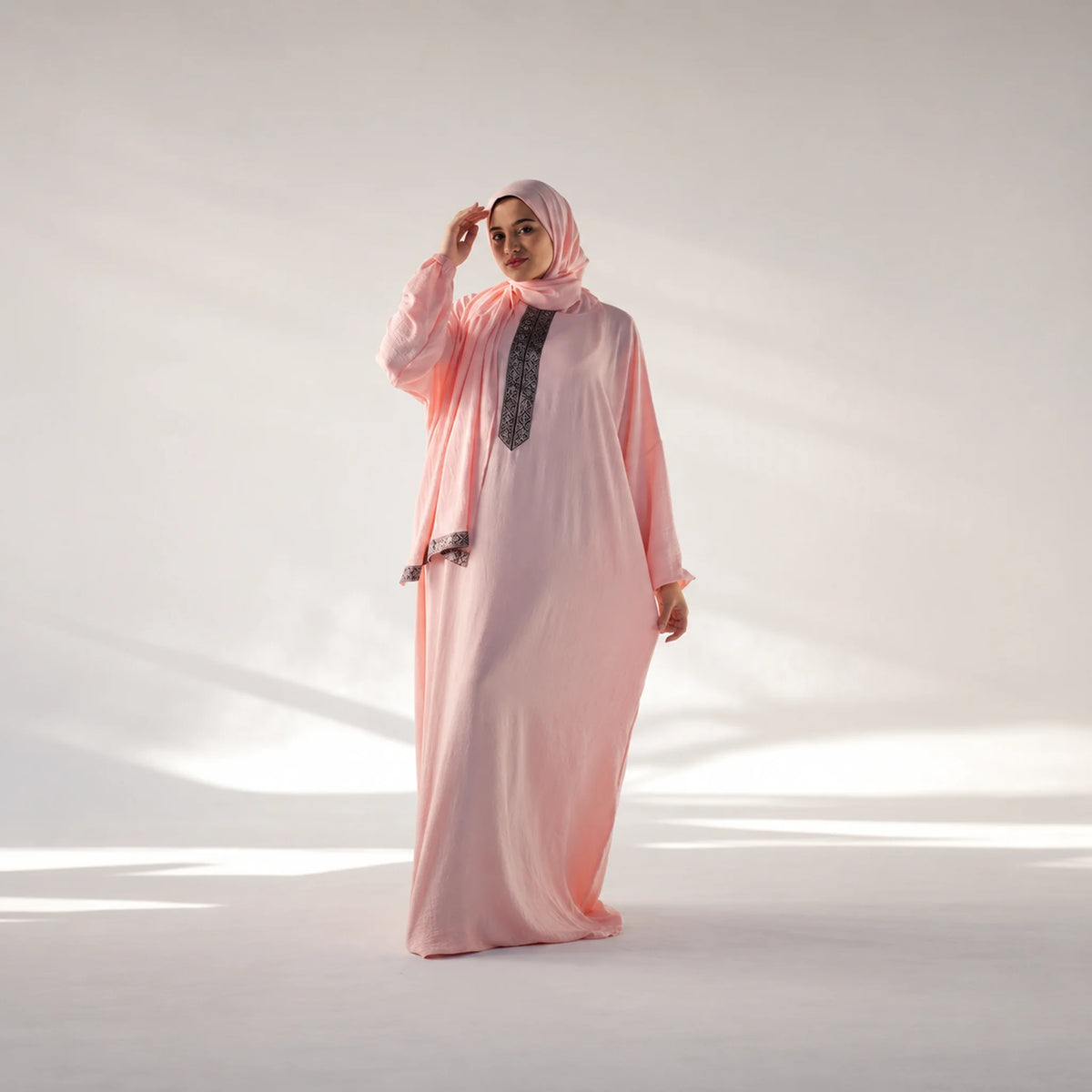 Model wearing Tallah's pink CY Isdal with black geometric placket trim, gallery photo 1