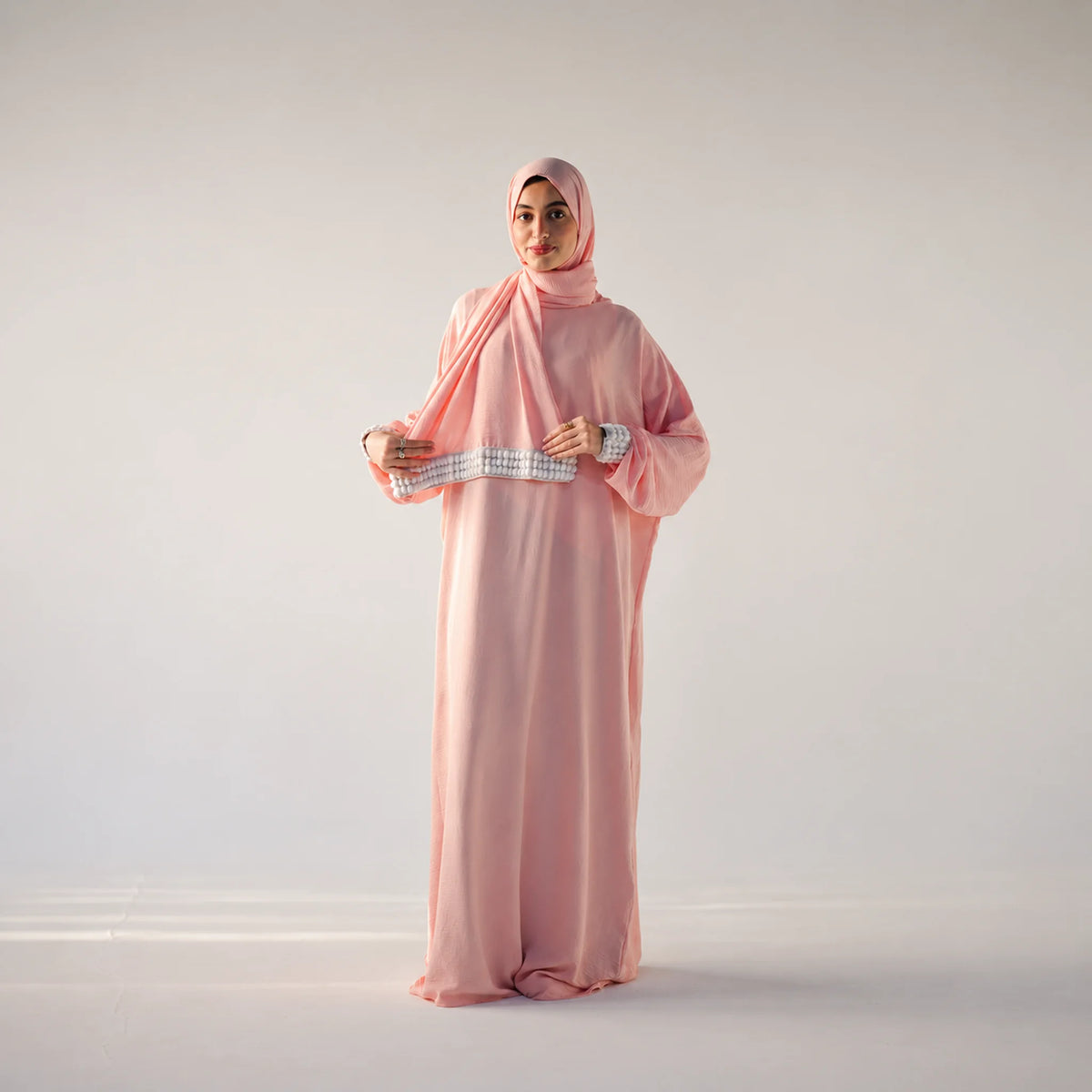 Model wearing Tallah's pink CY Isdal with pearl cuff trim, gallery photo 1