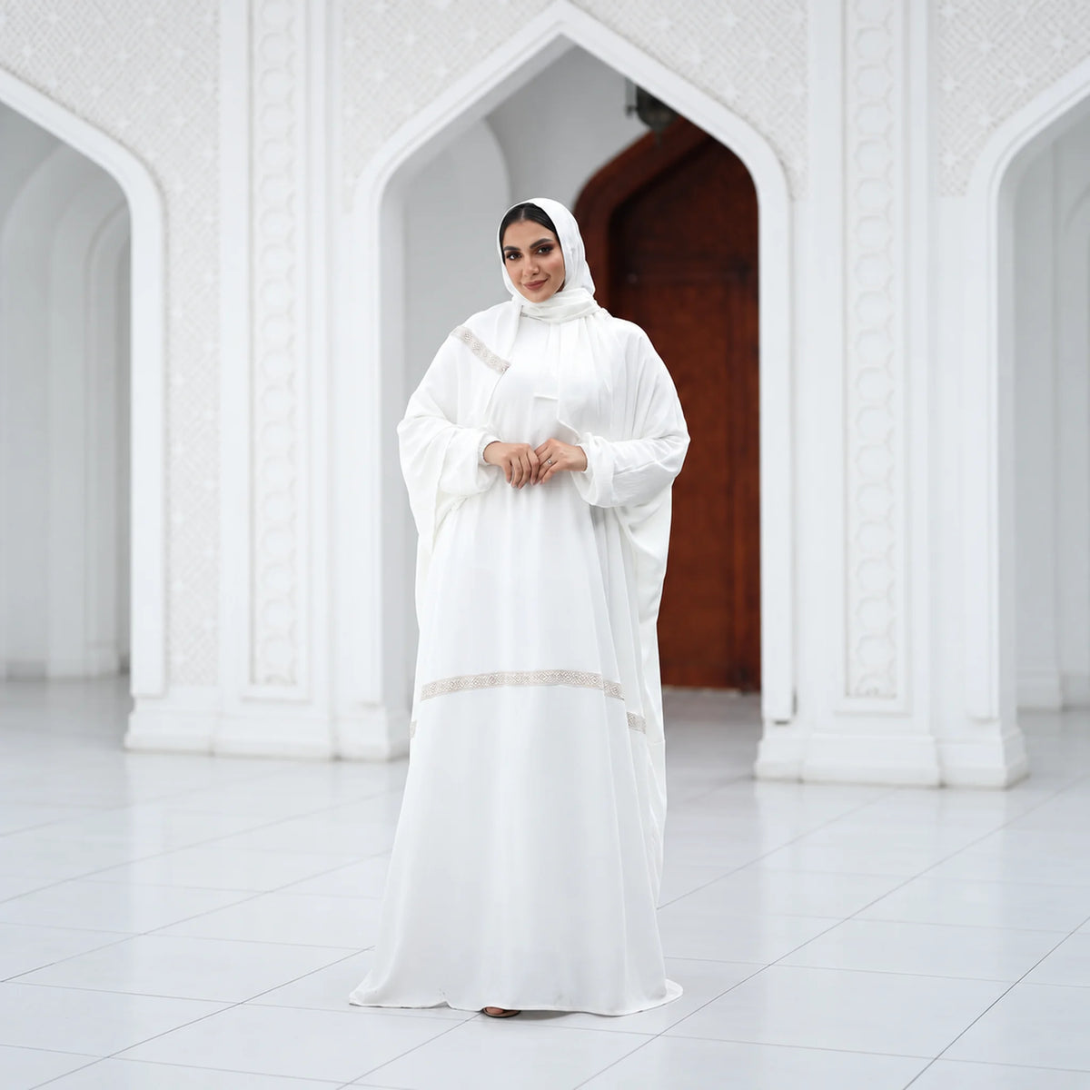 Model wearing Tallah's white CY Isdal with diagonal beaded trim, from the Hajj & Umrah line, gallery photo 2