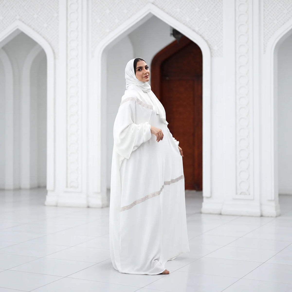 Model wearing Tallah's white CY Isdal with diagonal beaded trim, from the Hajj & Umrah line, gallery photo 4