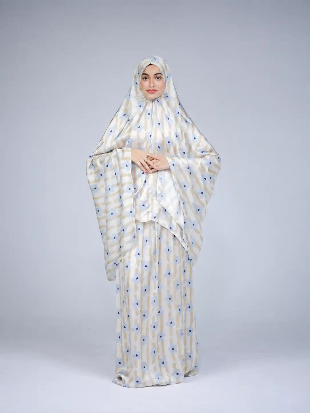 Model in a white small-print Tallah khimar and jibbah set against a grey backdrop