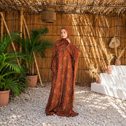 Model wearing Tallah's orange and rust Soft Mabrad Isdal with an ornamental print and matching veil.
