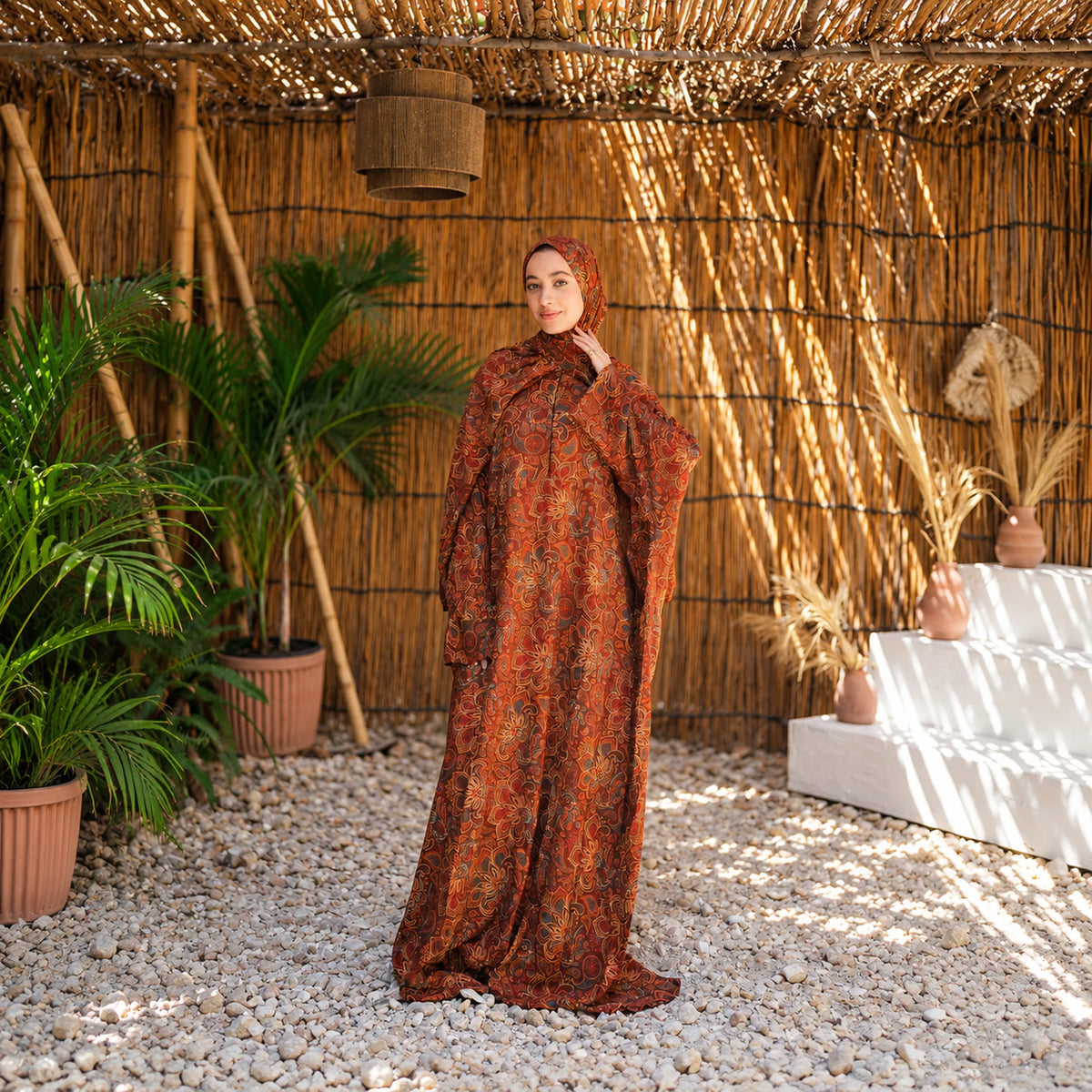 Model wearing Tallah's orange and rust Soft Mabrad Isdal with an ornamental print and matching veil.
