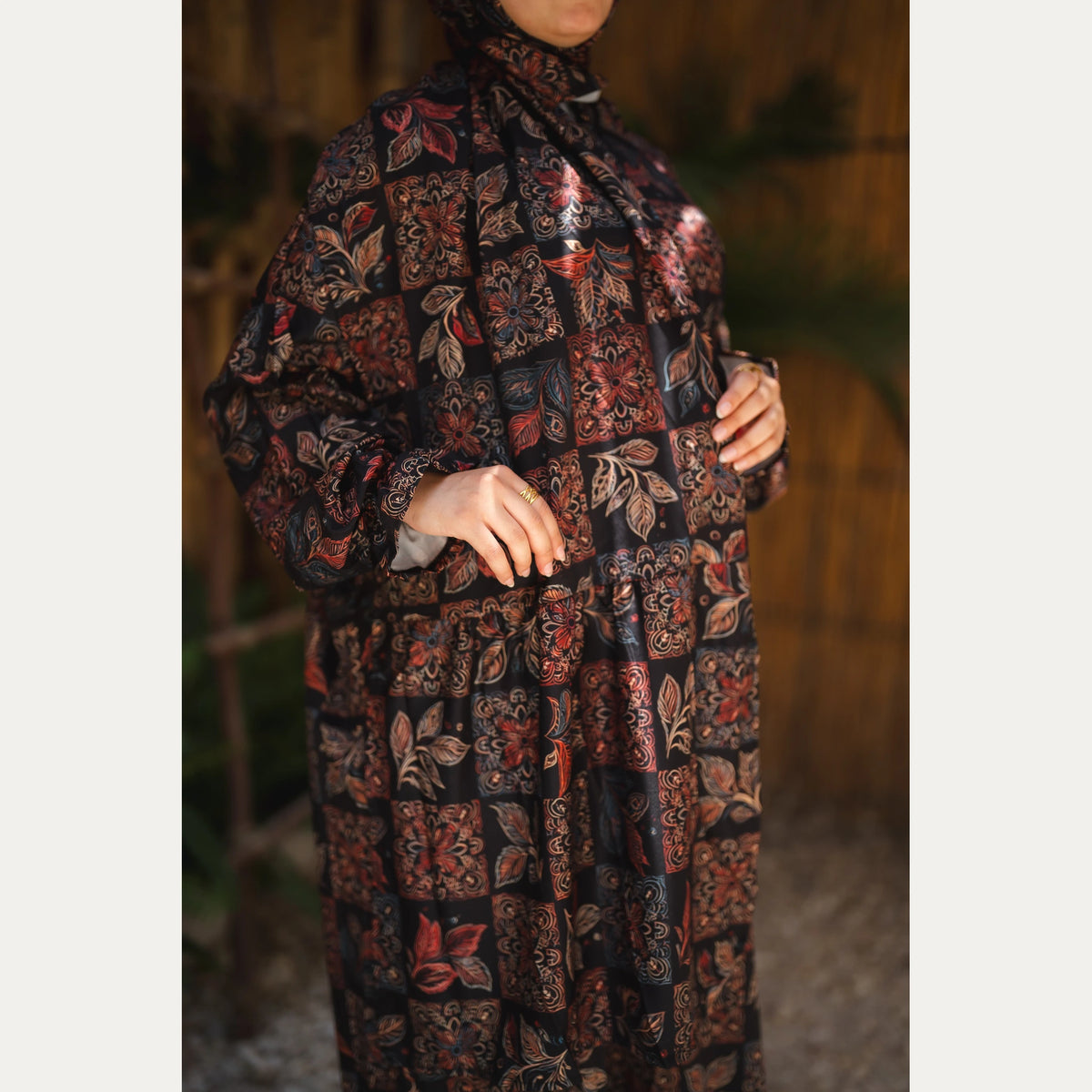 Tallah satin Isdal in Black and Rust, patchwork pattern, close-up of patchwork print, sleeve and front buttons.