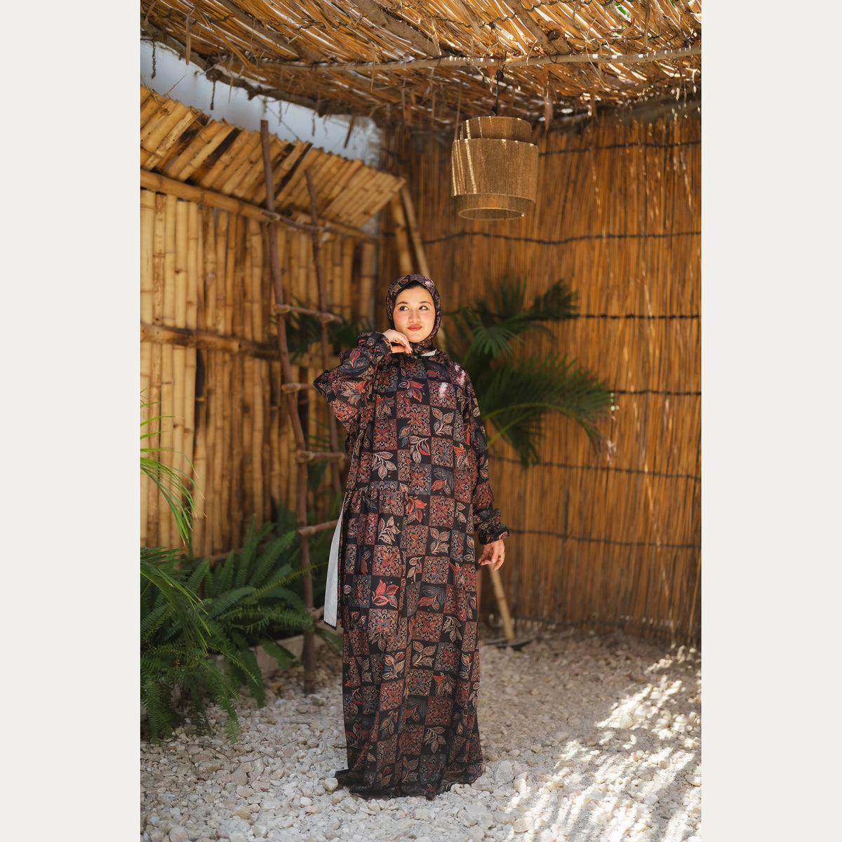 Tallah satin Isdal in Black and Rust, patchwork pattern, full-length front view with hand near chin.