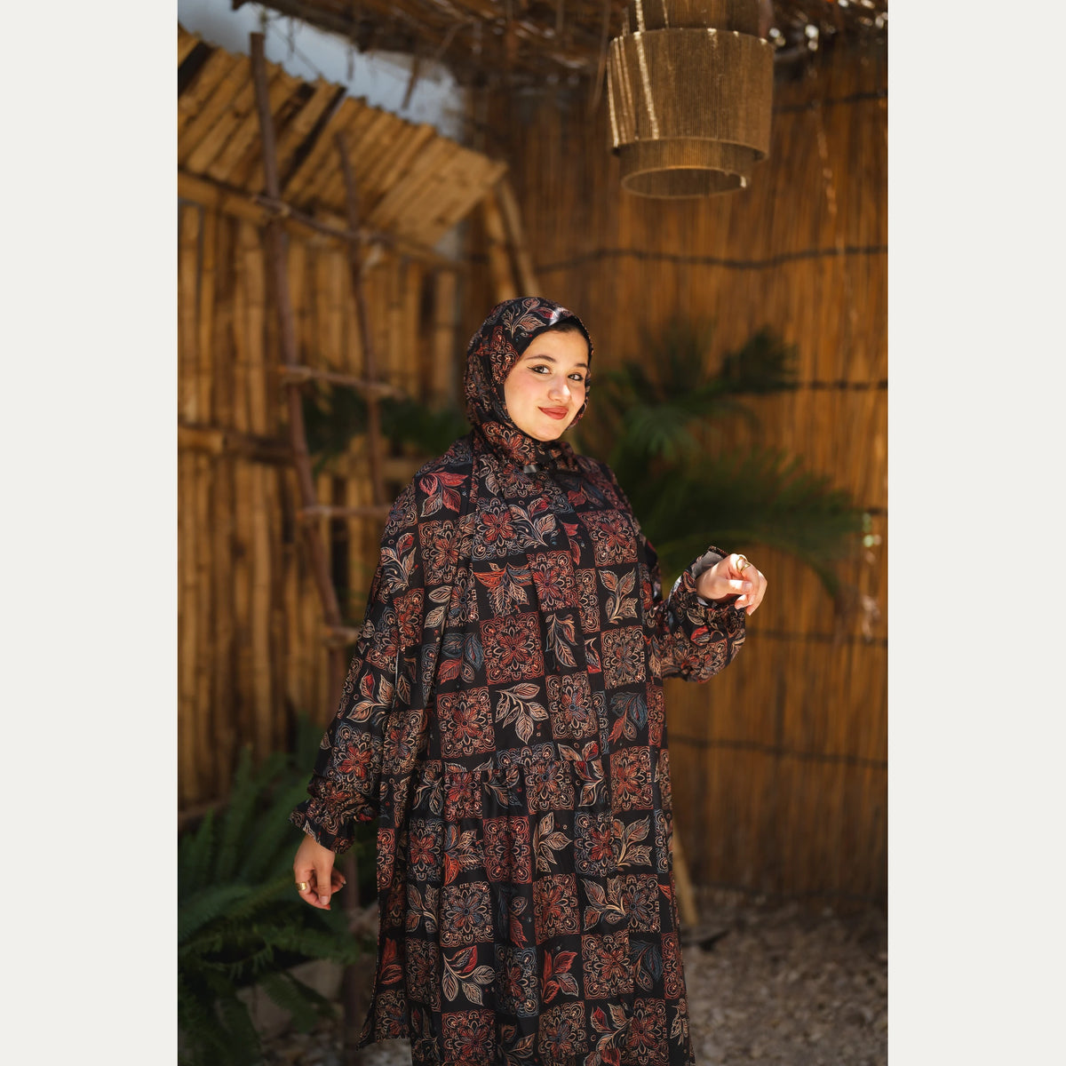 Tallah satin Isdal in Black and Rust, patchwork pattern, upper-body view with one sleeve raised.