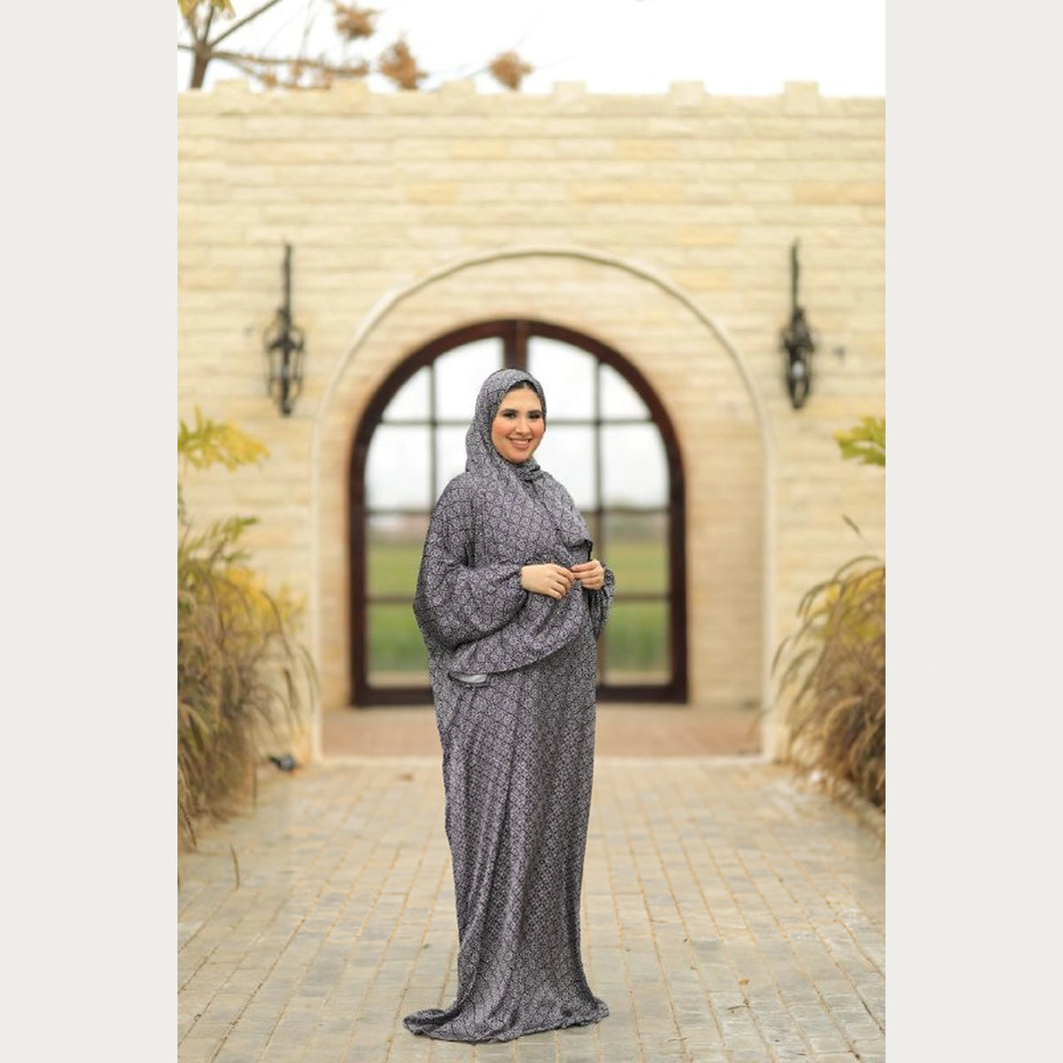 Tallah grey and black geometric satin Isdal, full-length three-quarter view with hands together at the waist.
