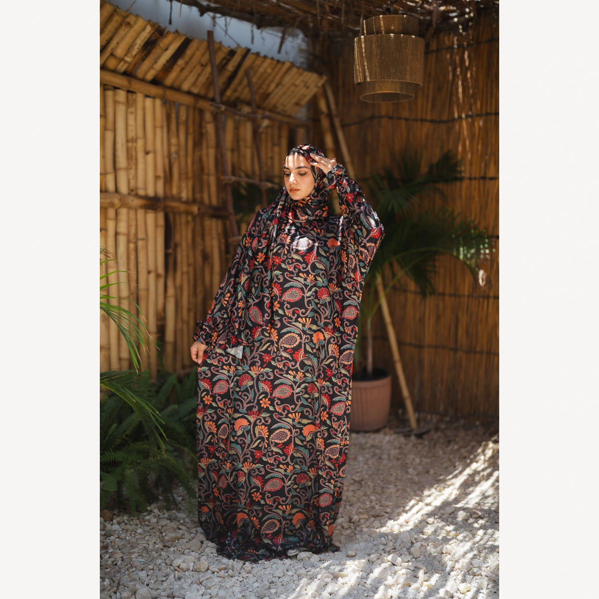 Tallah satin Isdal in black red orange paisley, full-length front view with head turned down.