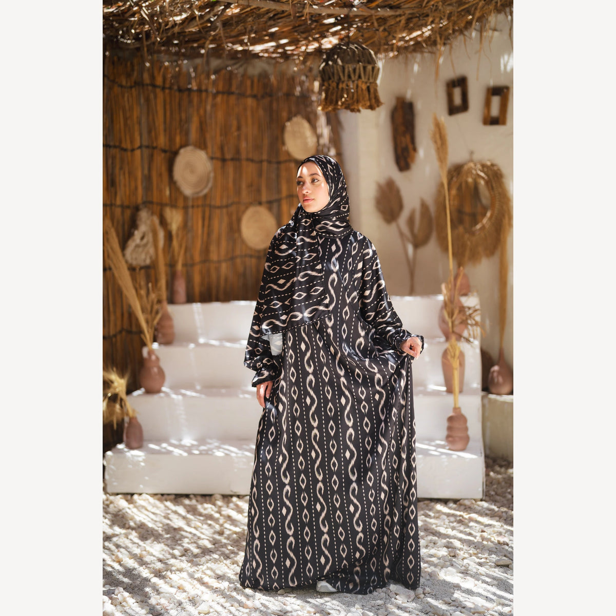 Tallah satin Isdal in black white wave, full-length front view with one arm extended.