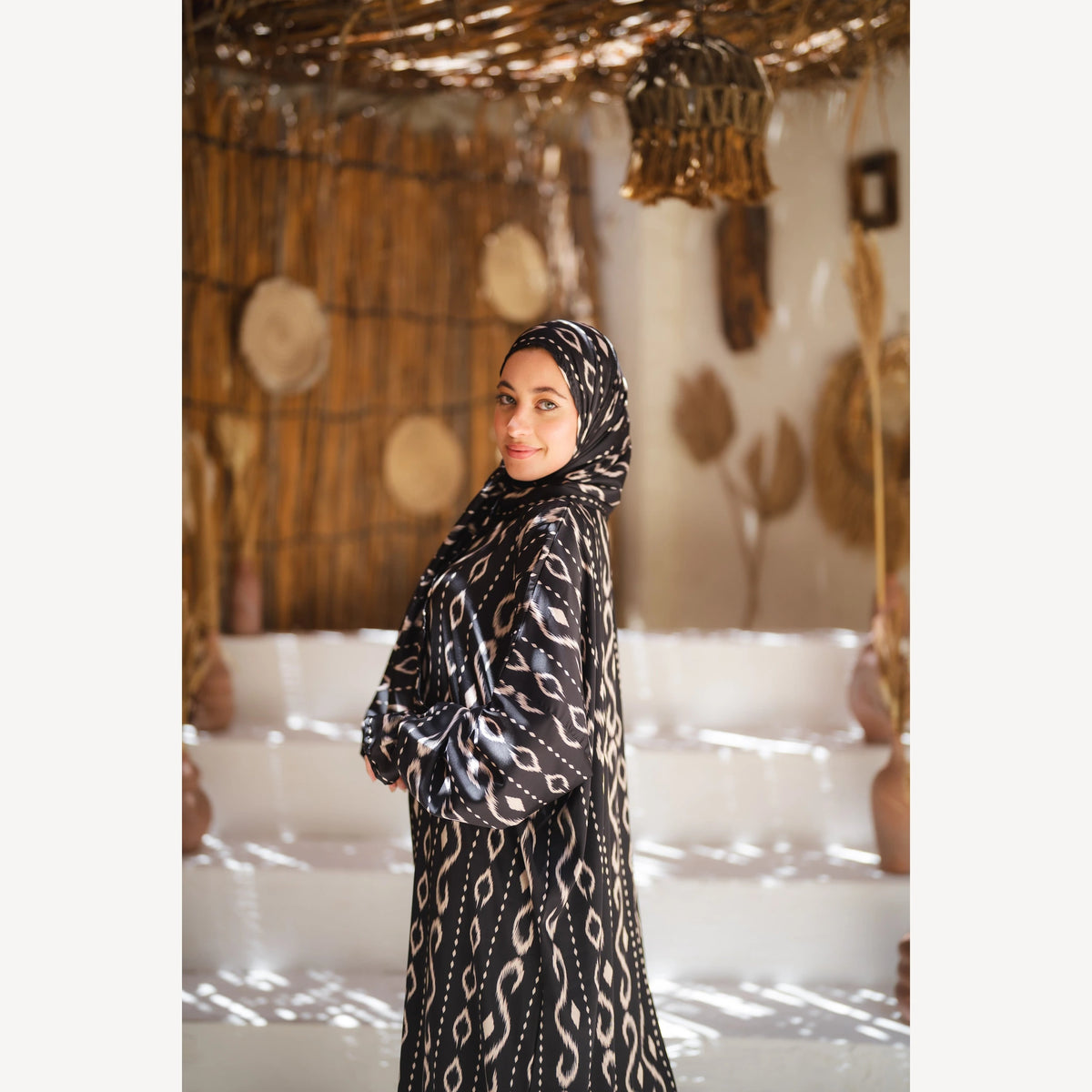 Tallah satin Isdal in black white wave, closer side view showing head covering and sleeve.