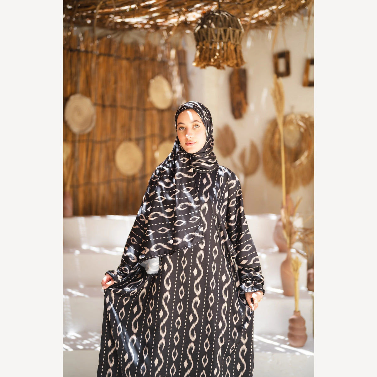 Tallah satin Isdal in black white wave, closer front view showing head covering and bodice.