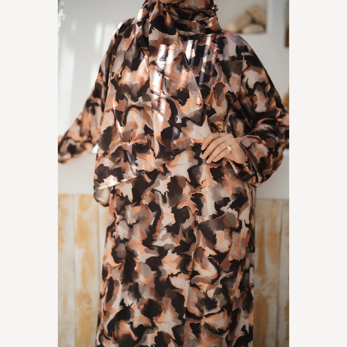 Tallah satin Isdal in brown black cream abstract, close-up of patterned bodice, sleeve and hand.