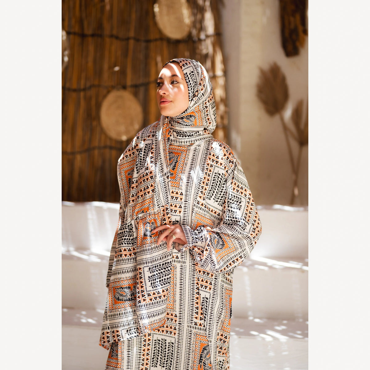 Tallah satin Isdal in cream black orange geometric, closer three-quarter view showing head covering and sleeves.