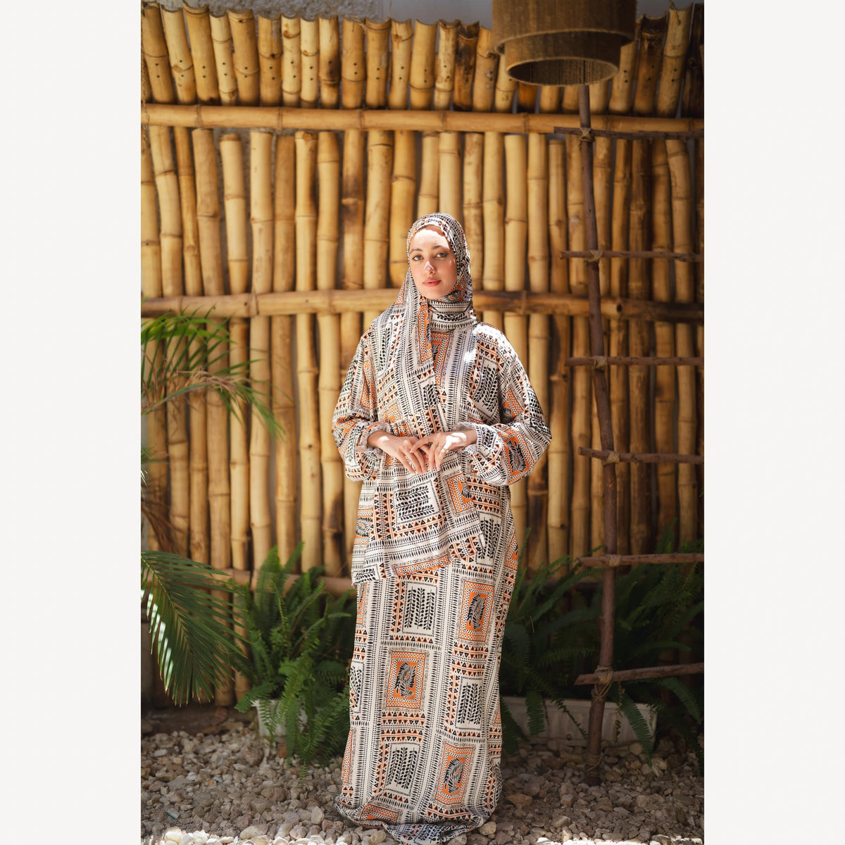 Tallah satin Isdal in cream black orange geometric, full-length front view against bamboo wall.