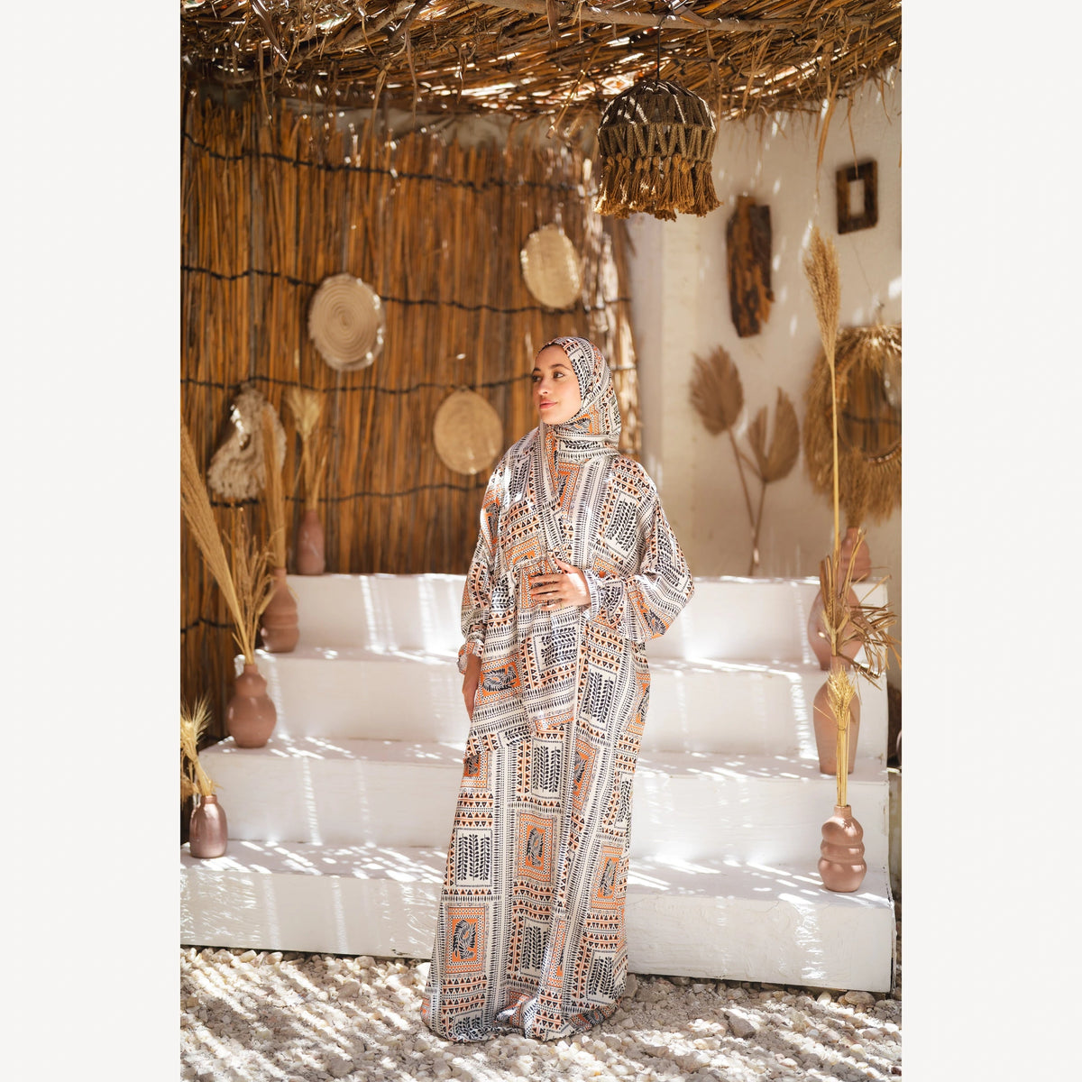 Tallah satin Isdal in cream black orange geometric, full-length three-quarter view with hands together.