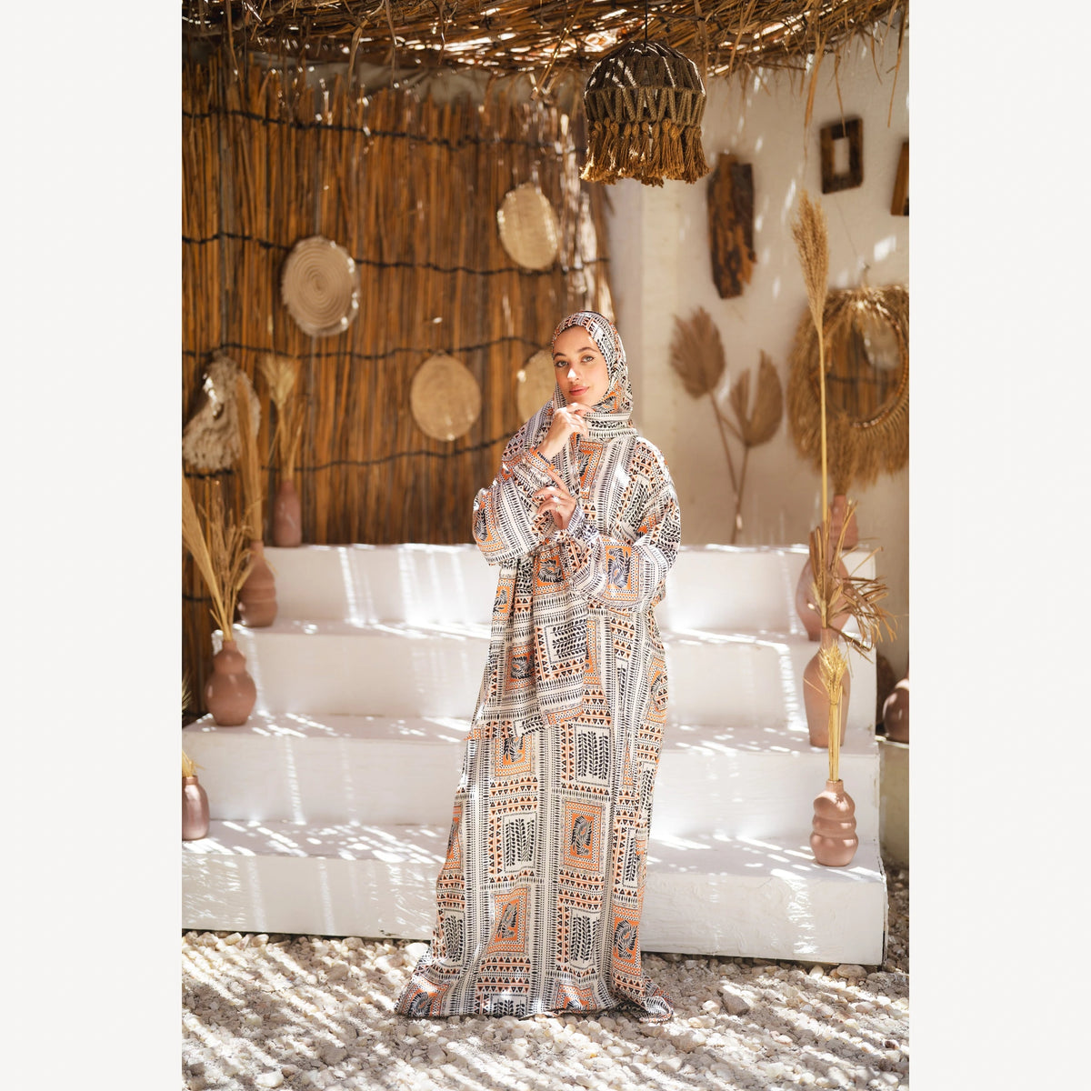 Tallah satin Isdal in cream black orange geometric, full-length three-quarter view with hand near chin.