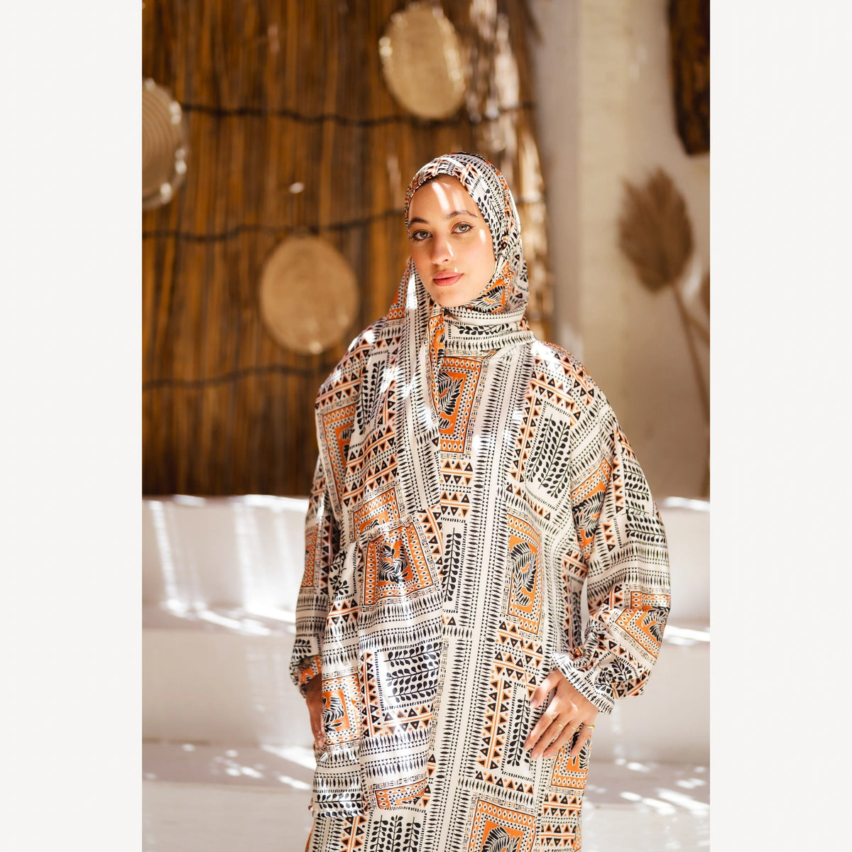 Tallah satin Isdal in cream black orange geometric, closer front view showing head covering and bodice.