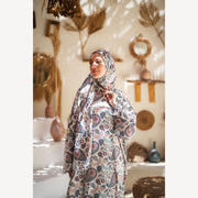 Tallah satin Isdal in cream navy rust paisley, closer three-quarter view with hand near chin.