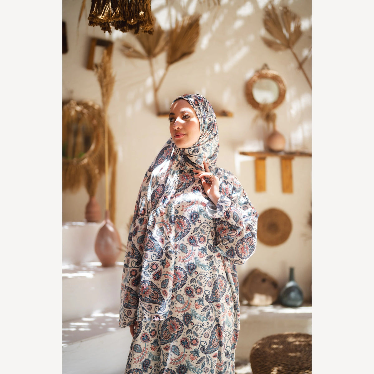 Tallah satin Isdal in cream navy rust paisley, closer three-quarter view with hand near chin.