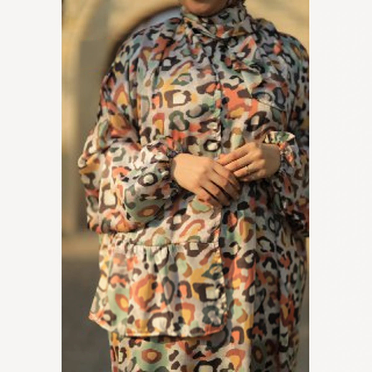 Tallah satin Isdal in cream orange brown leopard, close-up of bodice, sleeves and hands.
