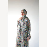 Tallah satin Isdal in navy green cream medallion, closer three-quarter view with hand near neck.