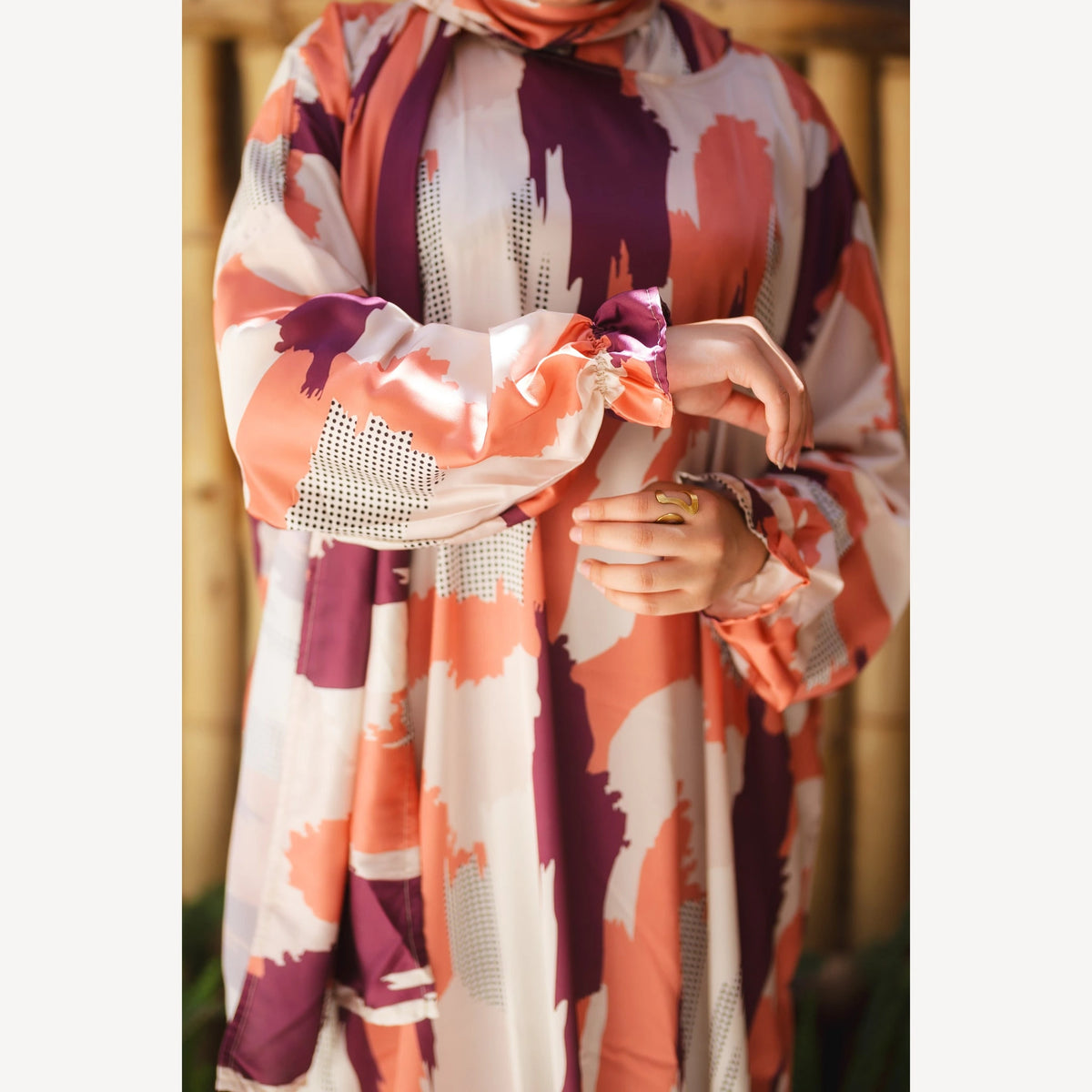Tallah satin Isdal in orange plum cream brushstroke, close-up of patterned satin bodice, cuff and hands.