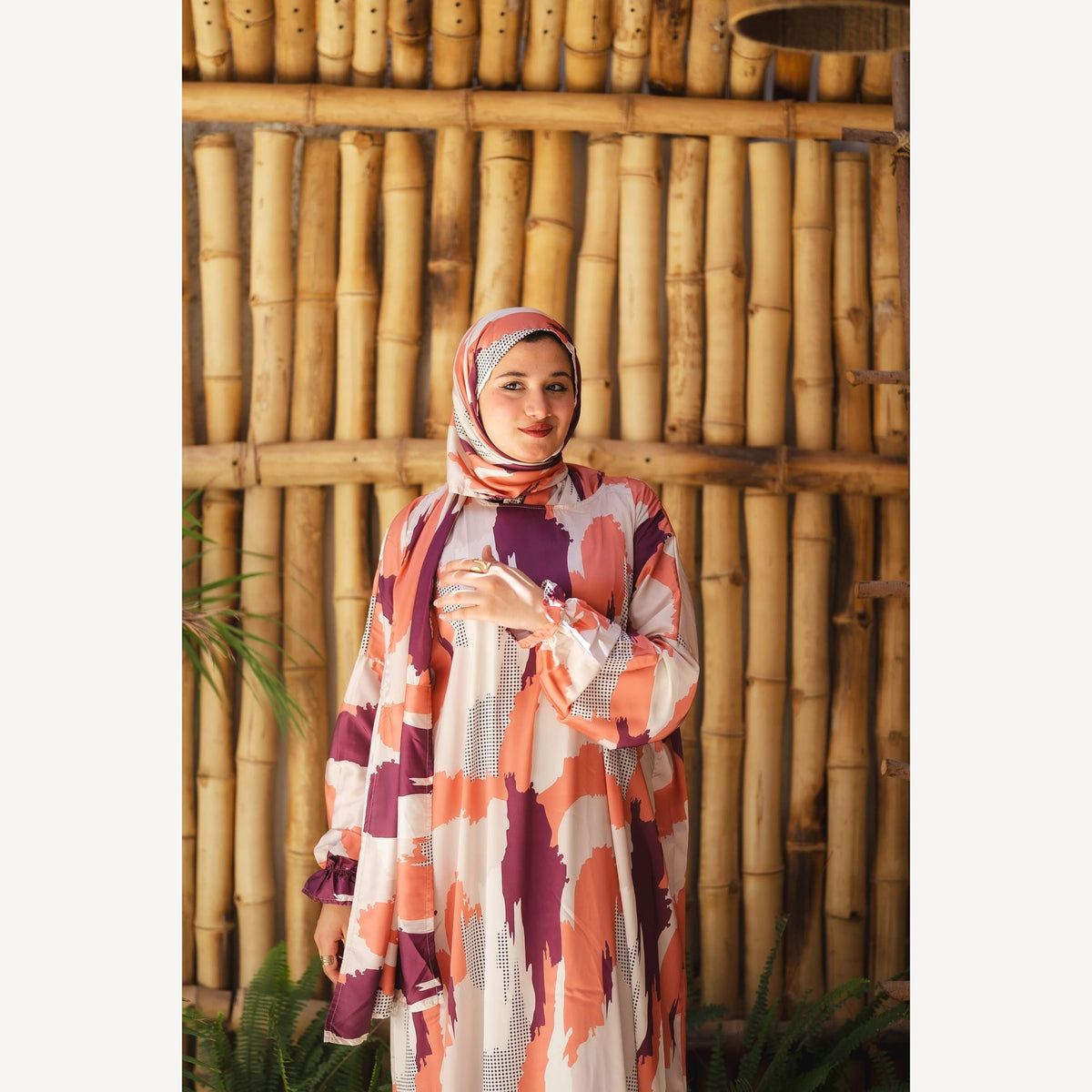 Tallah satin Isdal in orange, plum and cream with a brush-stroke pattern, closer three-quarter view showing sleeves and print.