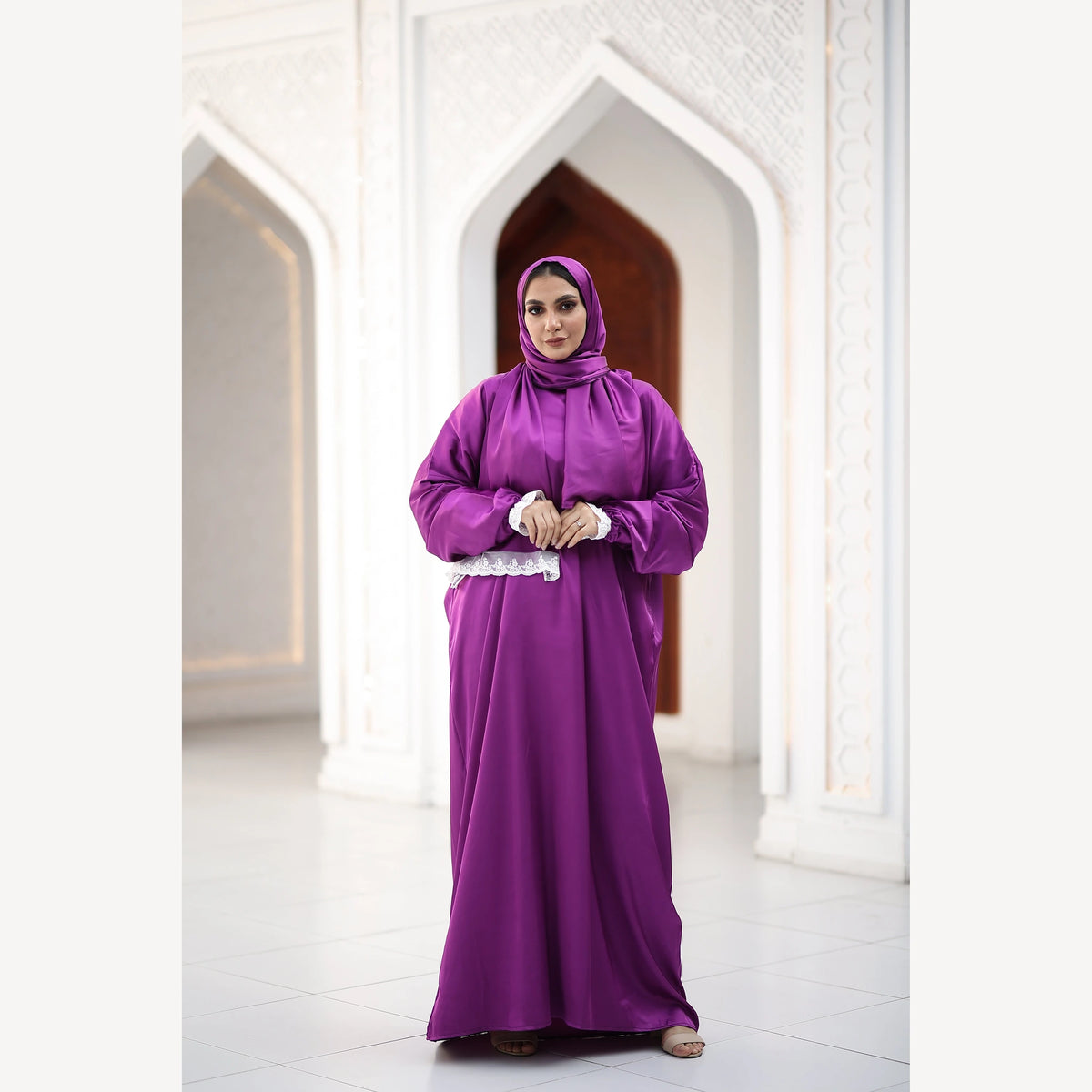 Purple satin Isdal with white lace cuffs and scarf trim, full-length front view against white arches.