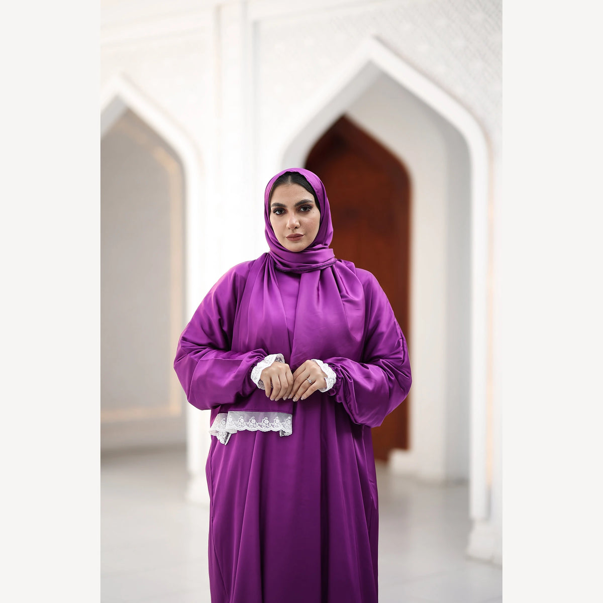 Purple satin Isdal with white lace cuffs and scarf trim, closer front view with hands together at the waist.