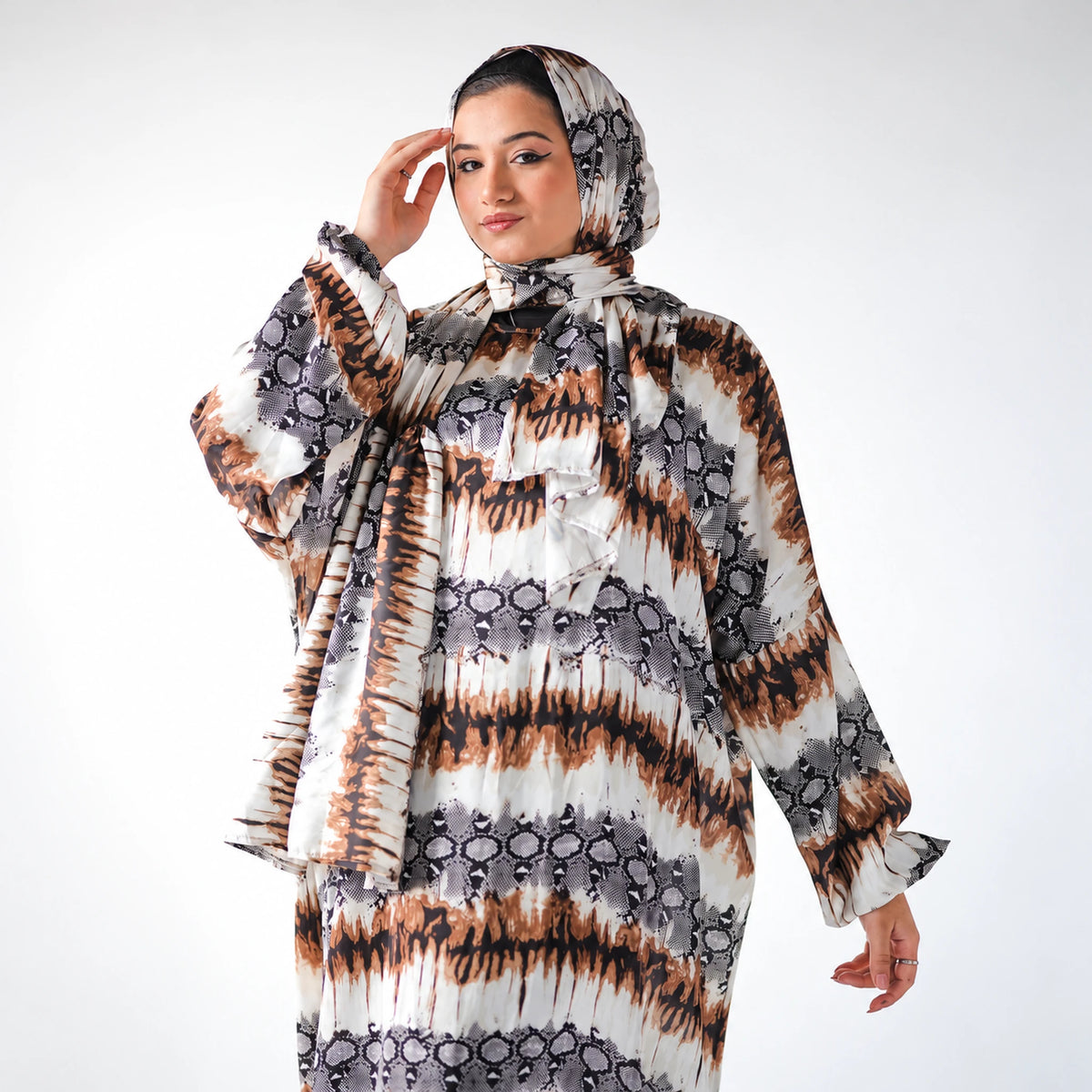 White, black and brown satin Isdal with an abstract animal-inspired print, closer view with raised hand.